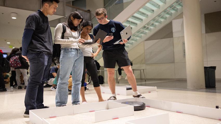 Students test code with robot in a maze. 