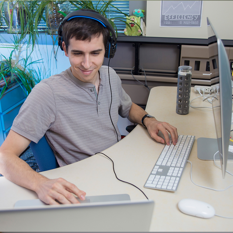 A man sitting at a desk with two monitors