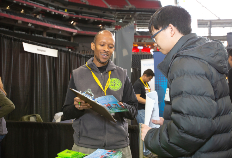 recruiter speaking with student at career fair