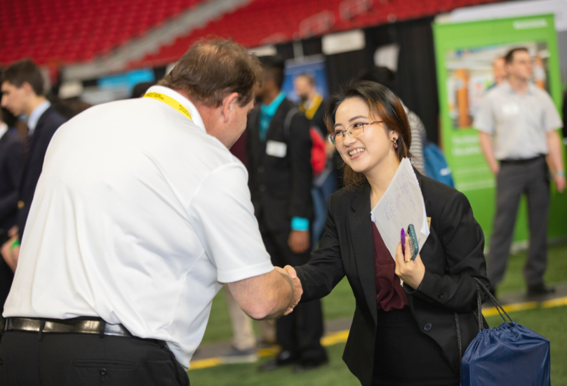 recruiter speaking with student at career fair