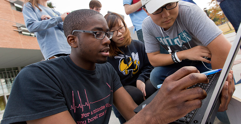 Students look at computer