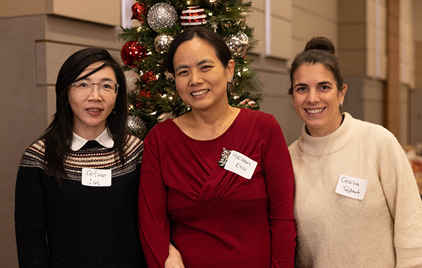 Three faculty at holiday party smiling