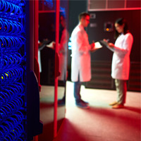 Two researchers next to computer servers