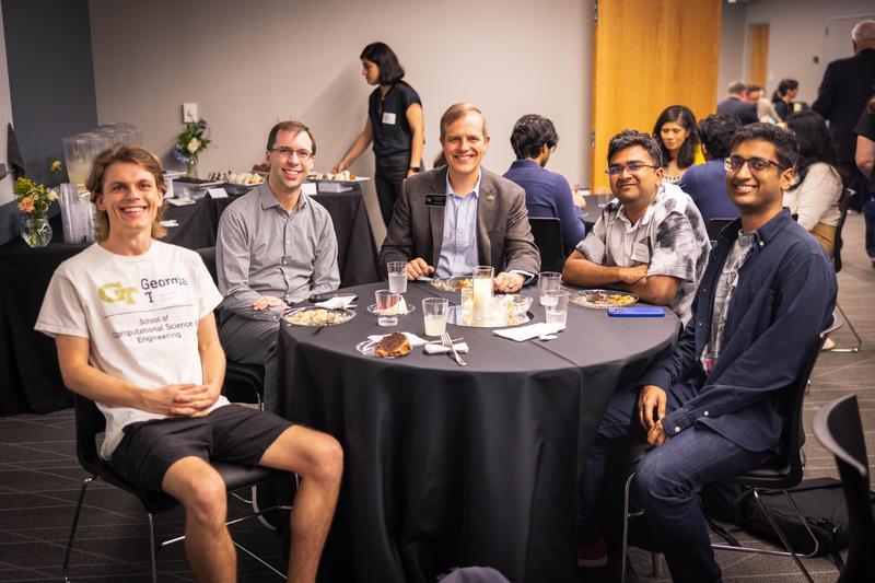Advisory board member and faculty member sitting with students