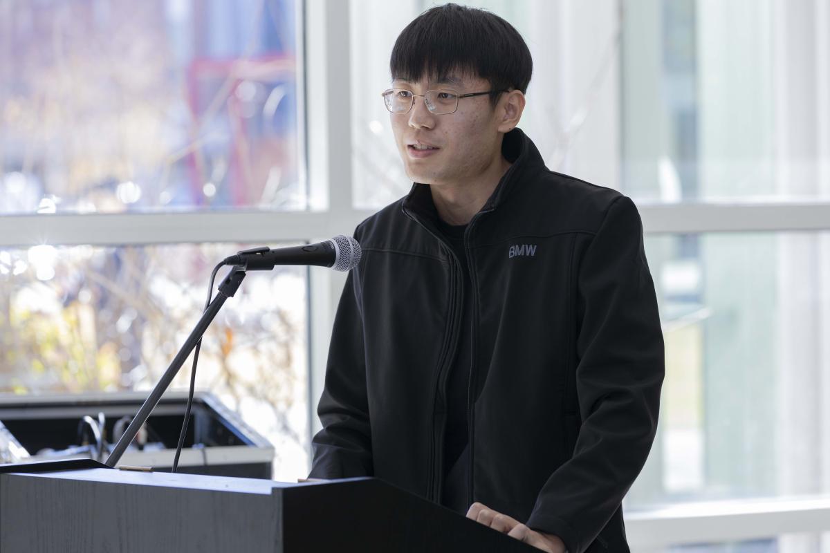 Speaker stands at a microphone to give a speech.