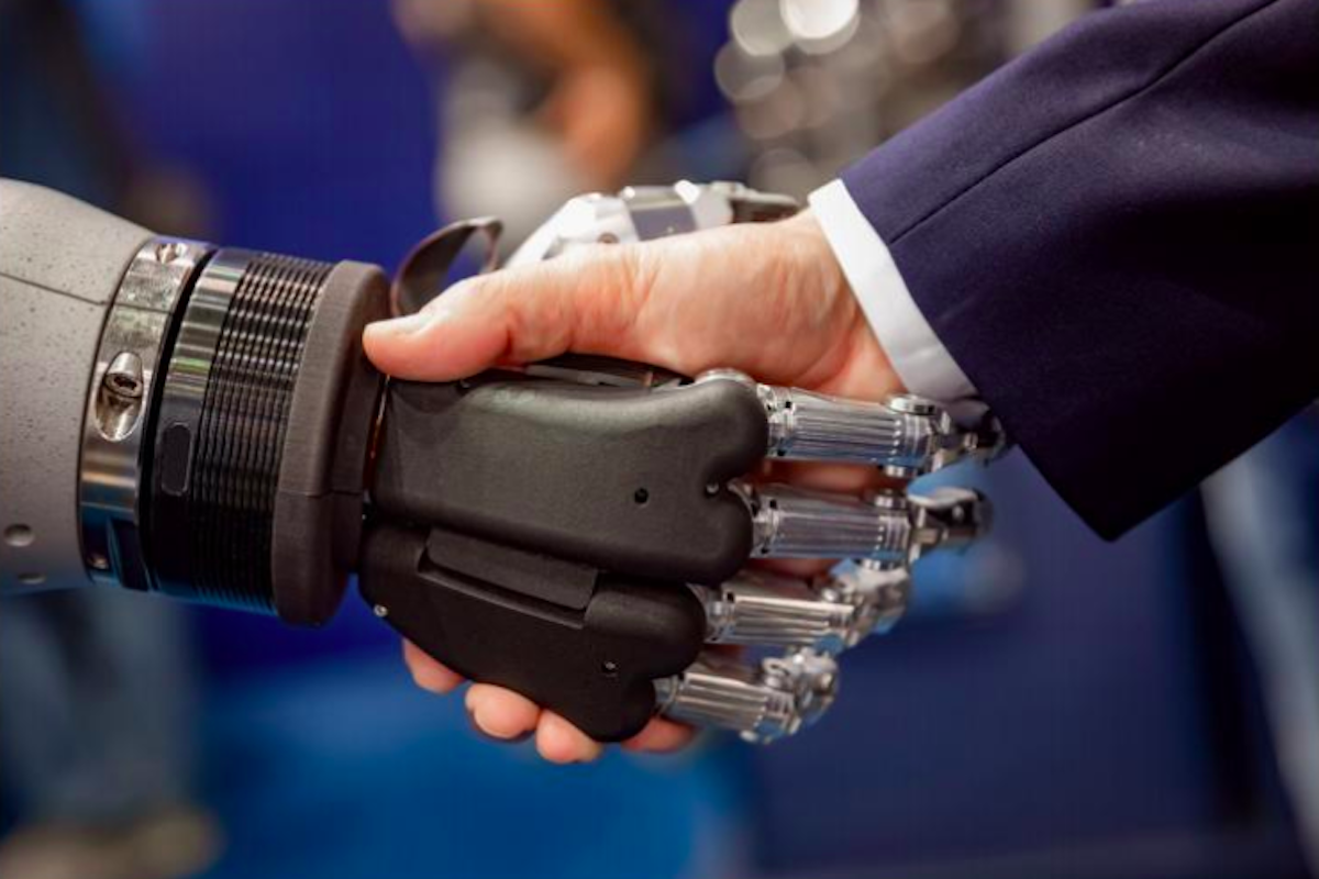 A robotic hand shakes a human hand