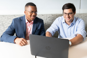 men working on laptop together