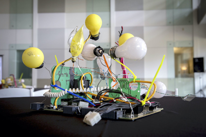 A luncheon table centerpiece made of lightbulbs, old motherboards, and wires.