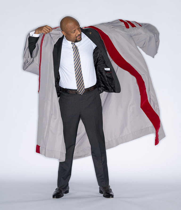 Charles Isbell putting on academic robe