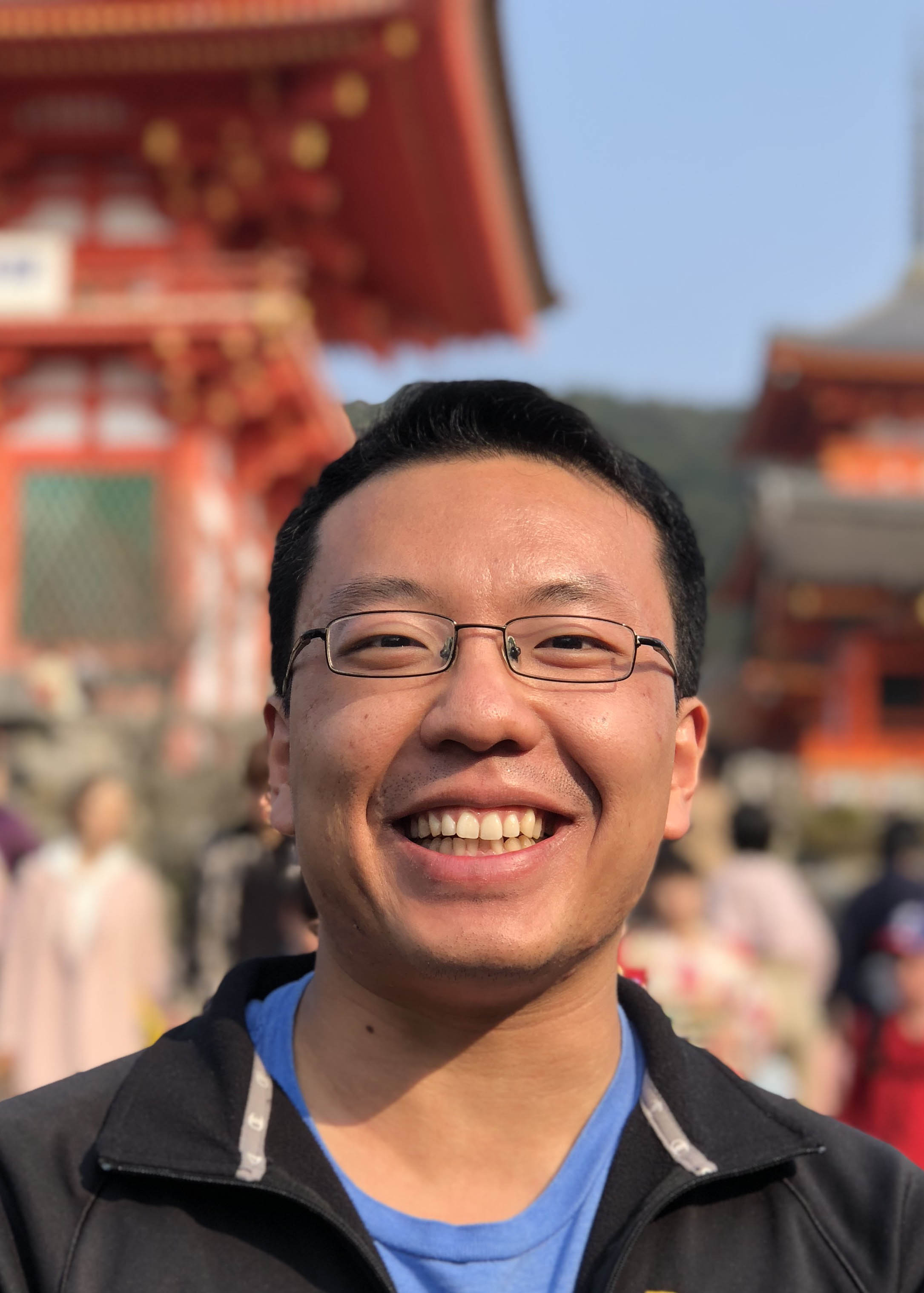 man wearing glasses in black jacket and blue shirt