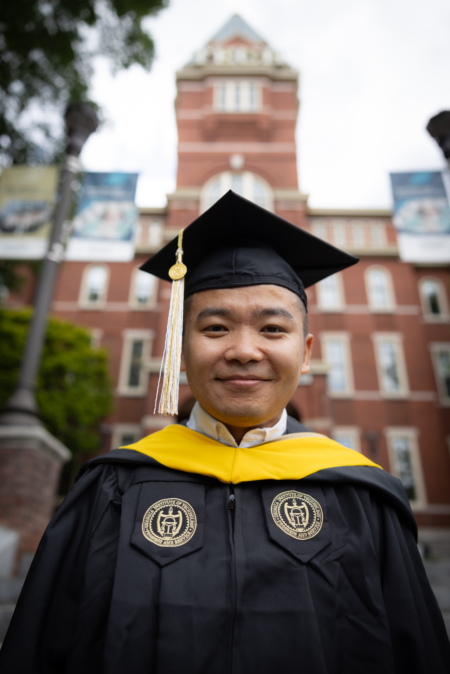 Man wearing graduation attire standing outside