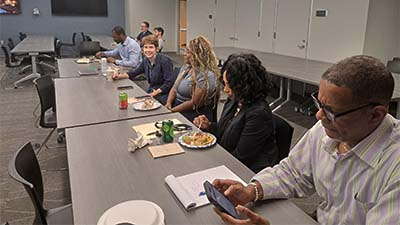 College faculty and staff members listen to student pitches.