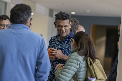 GT CS Professor Santosh Vempala shares a laugh with colleagues at Georgia Tech.