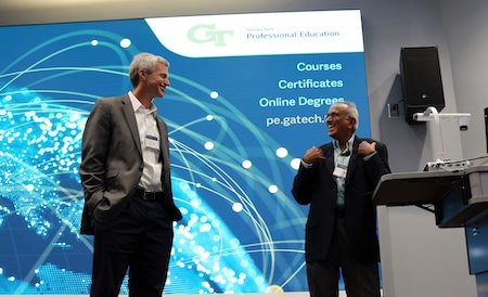 two men in front of presentation