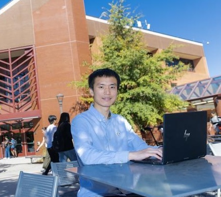 man sitting at table with laptop