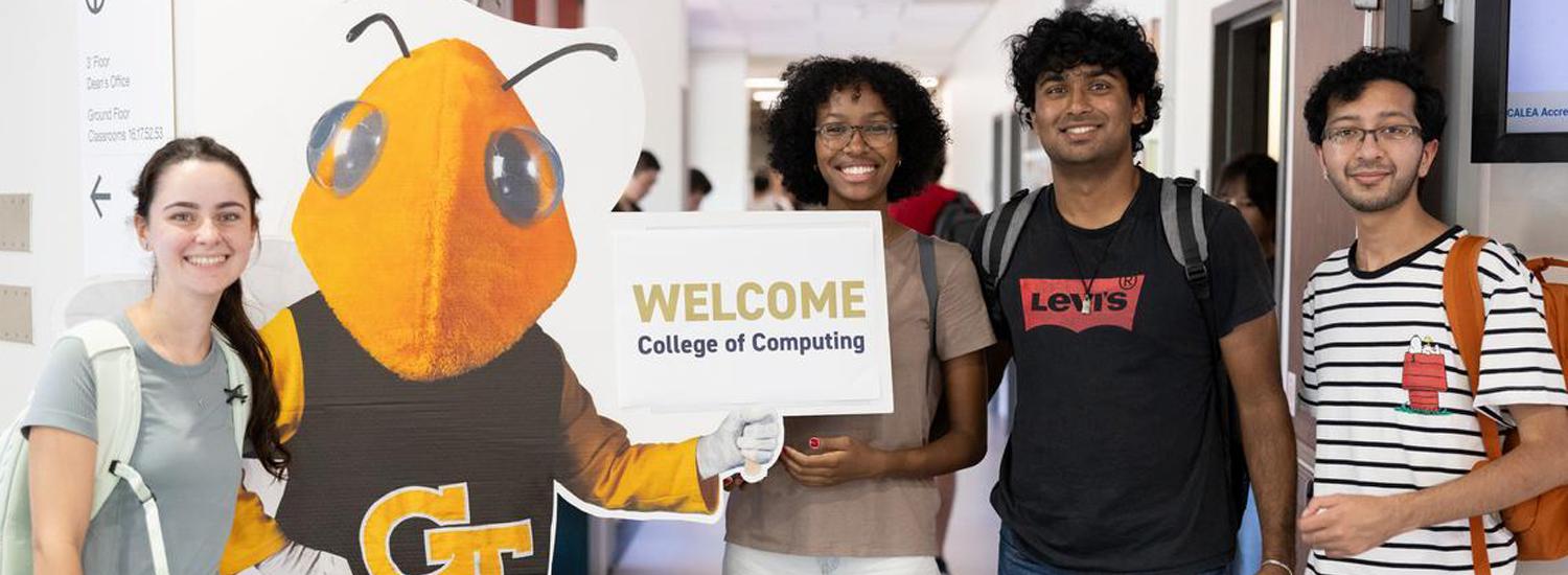 Students standing with a cardboard cutout of Buzz and a sign that says "Welcome"