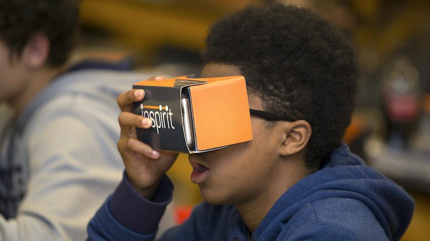 High school kid using a cardboard virtual reality viewer in his biology class to learn about plant cells