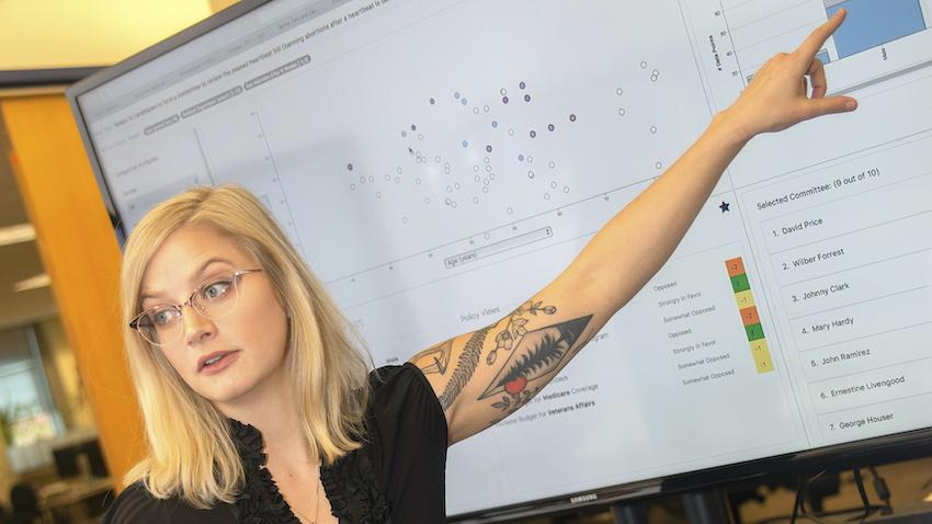 A GT Computing graduate student presents at a white board