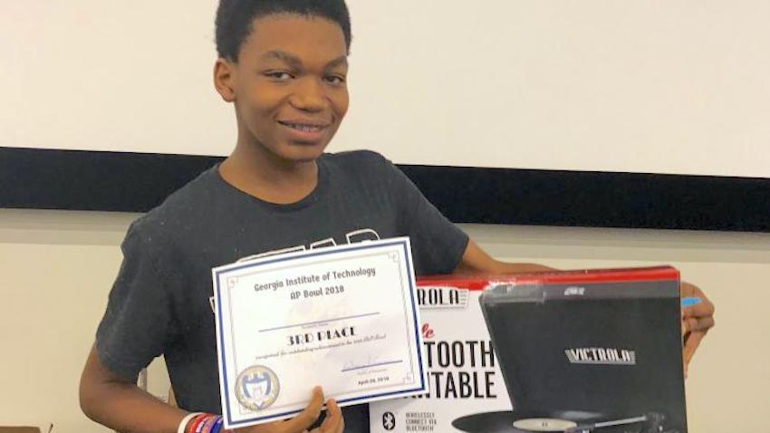 YOung man displaying a 3rd place certificate for the AP Bowl at GT Computing