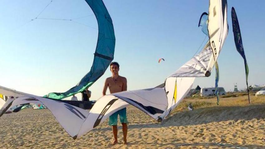 Man on beach with kitesurfing sails