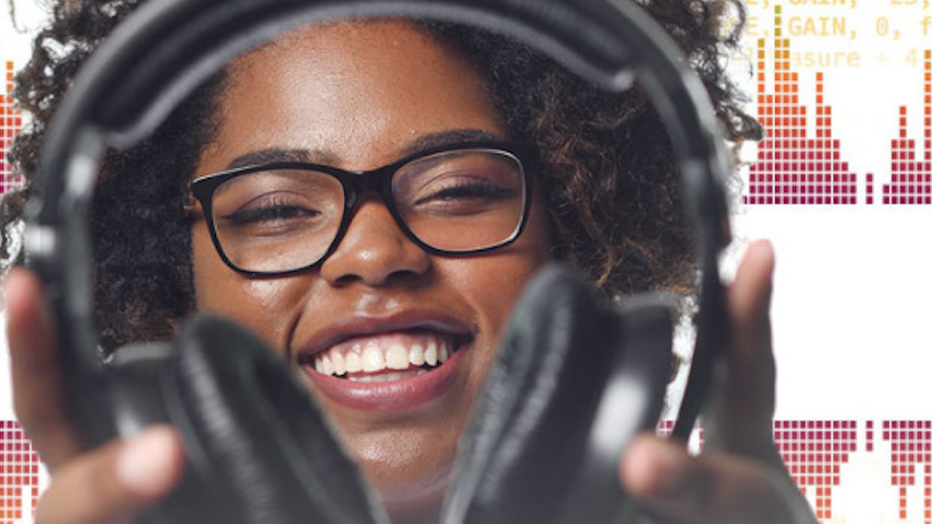 a young woman with big smile holding out headphones 
