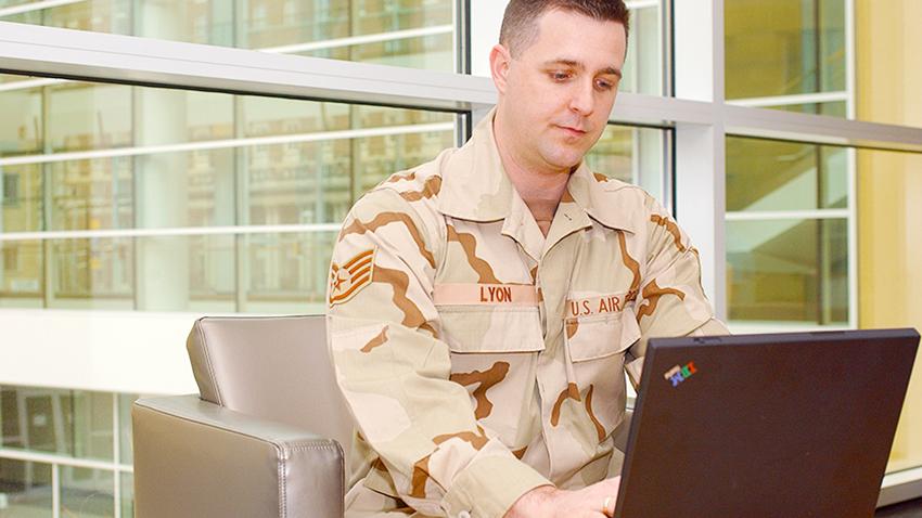 man in army uniform typing