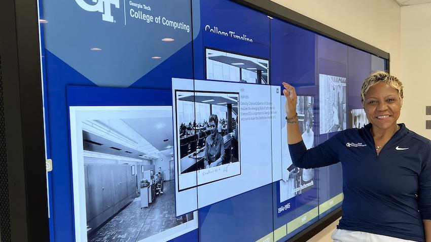 Georgia Tech Co0mputing Staff Member LaDonna Cherry poses beside a new interactive video display