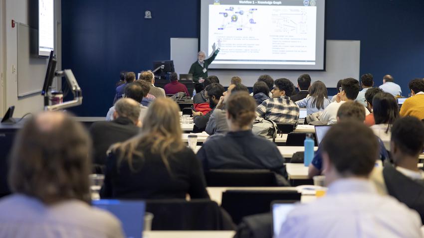 Wide shot from behind attendees listening to speaker's presentation at Georgia Tech's CRNCH Summit 2023