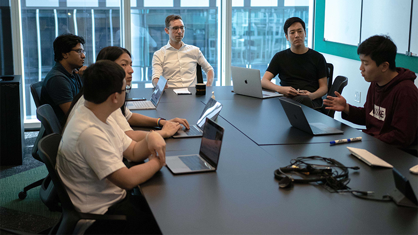 students and professor sitting around a table