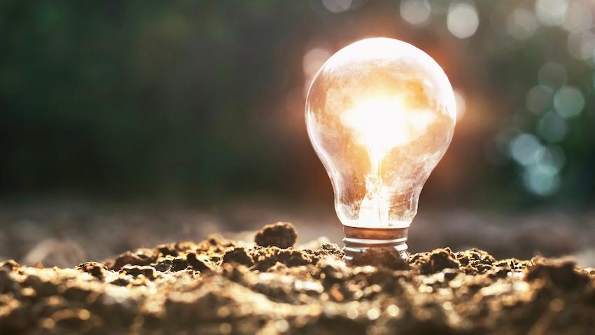 Lighted bulb in dirt illustrates new technology being developed at Georgia Tech.