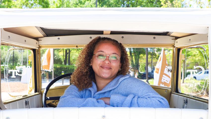 A woman sitting in the back of the Ram,bling Wreck