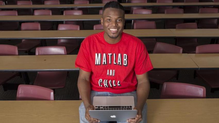 Georgia Tech Ph.D. student Kantwon Rogers smiling at the camera in a classroom.
