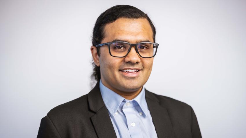 A man wearing glasses and a suit
