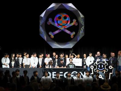 Team Atlanta stands on the dark DefCon stage during the convention's closing ceremony. 