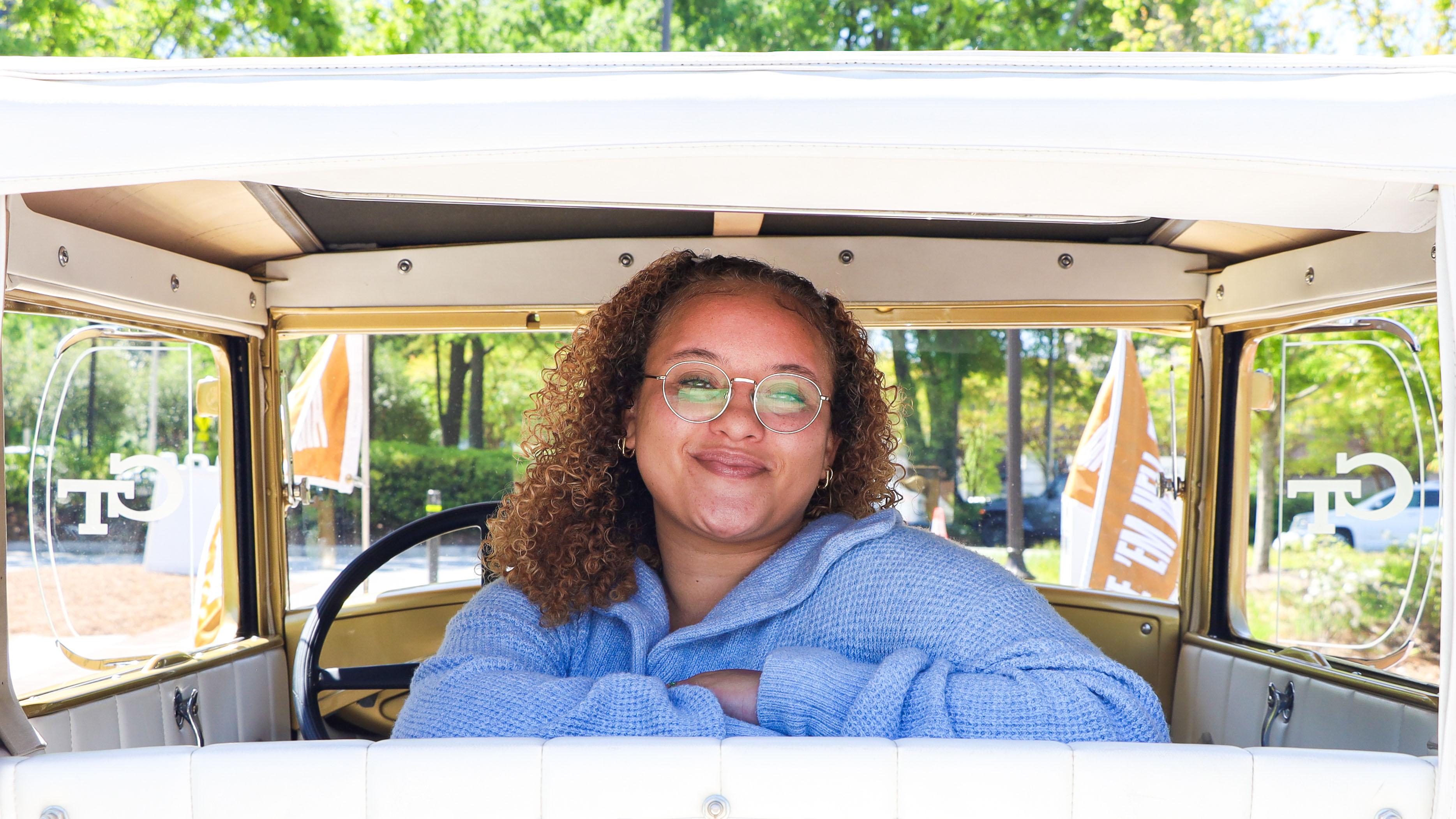 A woman sitting in the back of the Ram,bling Wreck