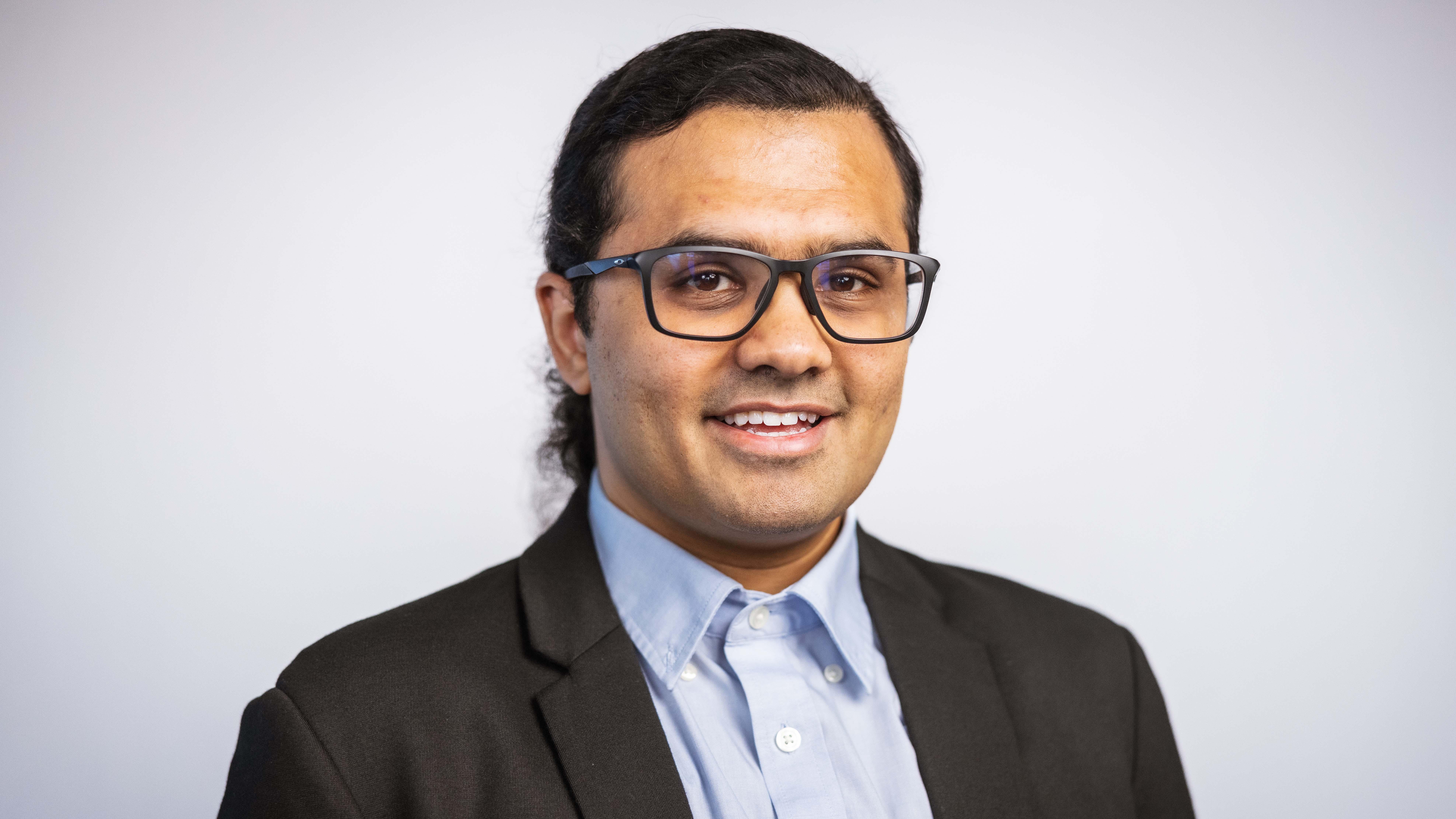 A man wearing glasses and a suit
